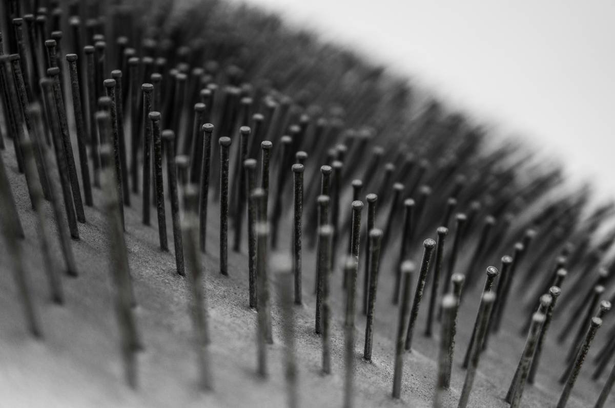 Side-by-side comparison of three hair detangler tools: a stiff paddle brush causing breakage, a wide-tooth comb gliding smoothly, and a flexible hair pick lifting curls without tangling