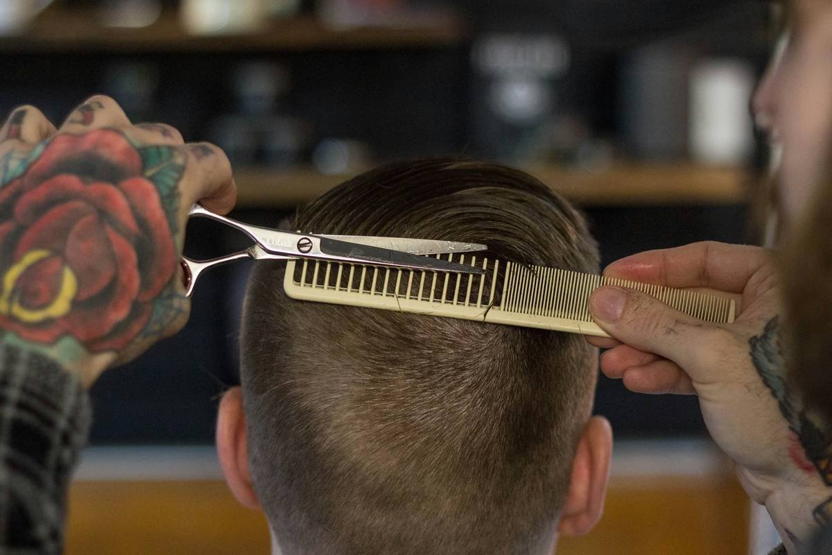 Woman using wooden hair pick to gently detangle afro hair for afro hair health