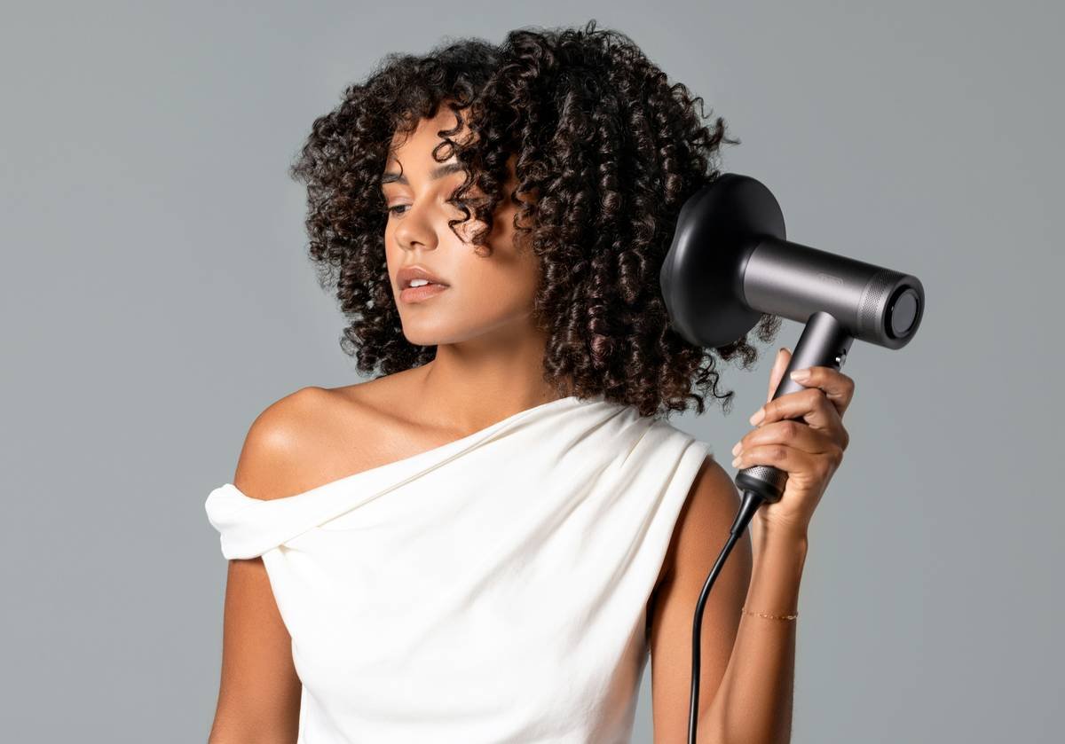 Woman using metal curly hair accessories to fluff voluminous afro