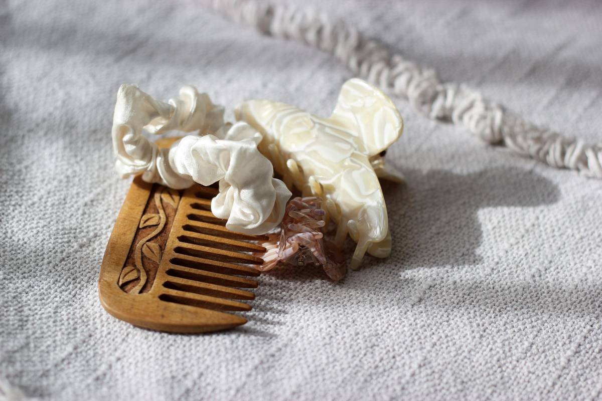 Assortment of artisanal wooden hair picks on linen fabric